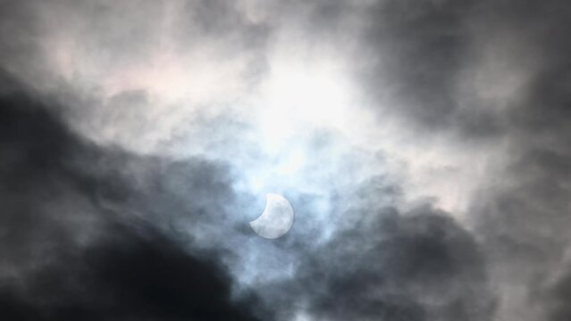 Partial eclipse of the Sun. Annular eclipse viewed through clouds. Moon in front of the sun. Solar eclipse. 