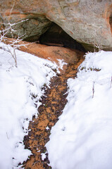 stream through snow from a cliff in winter