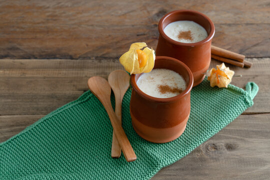 Bowls of rice pudding and cinnamon on a wooden background. Copy space.