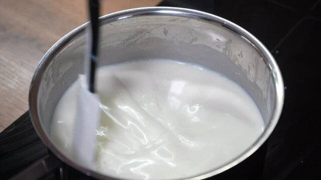 Cooking delicious creamy bechamel sauce of perfect consistency in frying pan