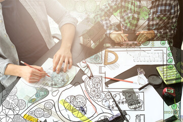 Double exposure of drawing and landscape designers working at table in office