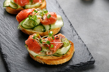 Healthy toasts with salmon, sliced cucumbers and microgreens . Bruschetta, snack, appetizers....