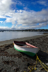 Water-filled row boat beached on shore