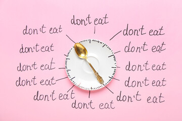 Saucer, spoon and text DON'T EAT on color background. Anorexia concept