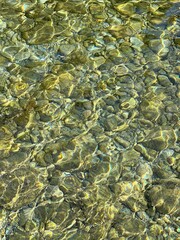 Fototapeta na wymiar Sea transparent water with smooth pebbles at the bottom.