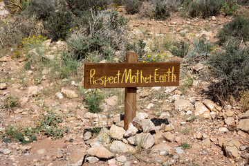 A wooden sign that reads respect mother earth, in the middle of the desert of Arizona, the United States of America