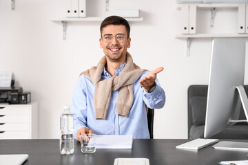 Naklejka na ściany i meble Smiling businessman working with documents at table in office