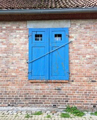 Obraz na płótnie Canvas Blue wooden window on brick wall