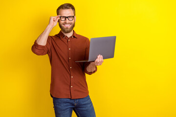Photo of satisfied positive glad man blond beard dressed burgundy shirt hold laptop touch glasses...