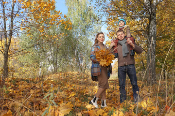 Naklejka premium happy family walking in autumn park.