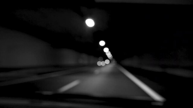 Driver defocused view on the dark illuminated highway by his far lights