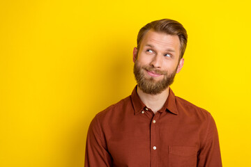 Obraz premium Photo of handsome thoughtful positive man with blond beard dressed burgundy shirt look empty space isolated on yellow color background