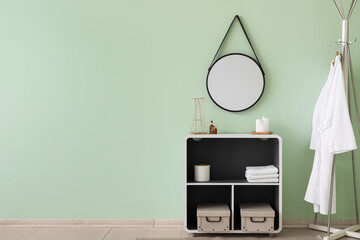 Interior of stylish bathroom with mirror, shelving unit and rack
