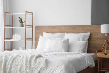 Interior of modern bedroom with big bed and shelving unit