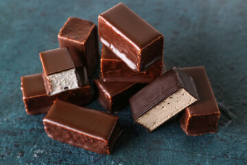Heap of tasty bird's milk candies on dark color background