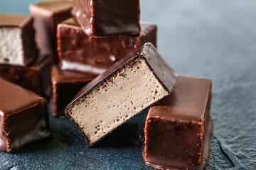 Heap of tasty bird's milk candies on dark color background, closeup