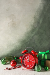 Red New Year clock and Christmas balls on grunge background