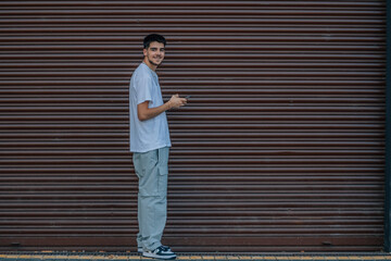 young man with mobile phone in the street full body
