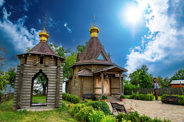 A Christian temple made of a wooden frame with a golden dome and a cross. Orthodox Church of...