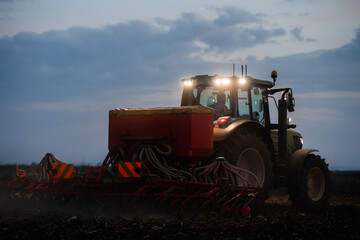 Tractor preparing land with seedbed cultivator
