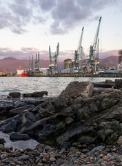 Port area. Cranes for ships. The atmosphere of a cargo seaport. Marine urban landscape.