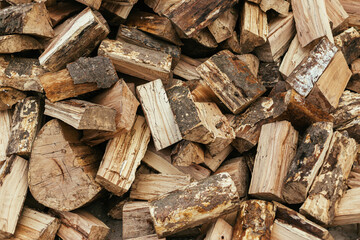 Firewood. Stack of firewood close up, wooden background. Chopped wood for fireplace heating, alternative to gas and electricity. Lumber pattern, log