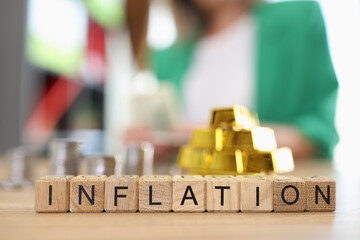 Inflation word collected with wooden cubes with gold ingots and coins