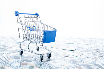 Shopping cart on the background of dollars.