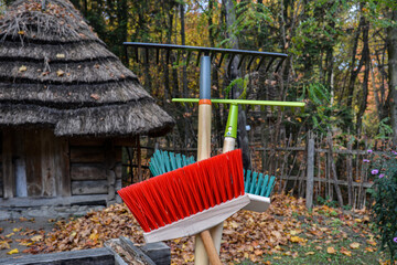 Metal rake and plastic broom on top