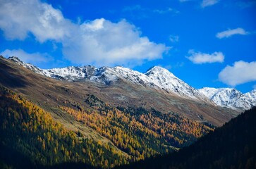 Fototapeta premium Davos mountain landscape in beautiful autumn. Snow on the mountain peaks and larch forests in the valley. Sentisch Horn. High quality photo