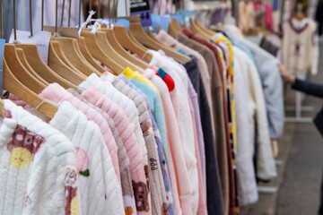 A shopping rank filled with clothes, pajamas and robes. Bunch of clothes of different colors for sale. Cheep clothing and fast fashion theme