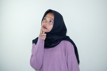 Portrait of thinking young Asian woman wearing hijab