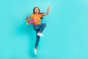 Full length size photo of little cute schoolkid girl jumping air with longboard celebrate weekend hobby chill fast ride isolated on aquamarine color background
