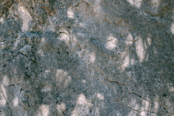 The texture of a large stone, part of a rock on a sunny day. Close-up. Macro