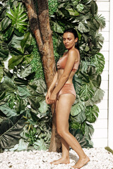 Slim brunette woman taking shower outdoor in tropical garden, organic skin care, luxury spa hotel, lifestyle photo
