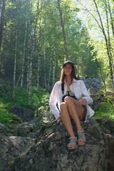 Girl tourist posing against the background of stones, rocks, nature. Day, forest.