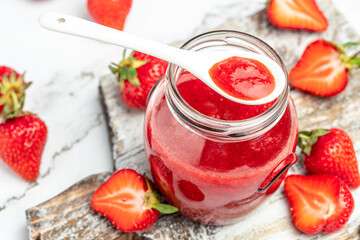 Jar of strawberry jam and fresh berries on white background. Homemade strawberry marmelade and fruit