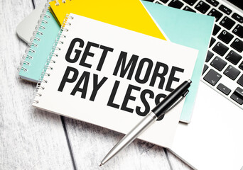Get more pay less words on yellow notebook and pen, charts and laptop