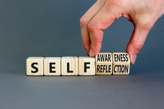 Self reflection awareness symbol. Concept words Self reflection and self awareness on cubes. Beautiful grey background. Psychologist hand. Psychological self reflection awareness concept. Copy space
