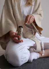 Woman holding white sage stick. Smudging energy clearing concept