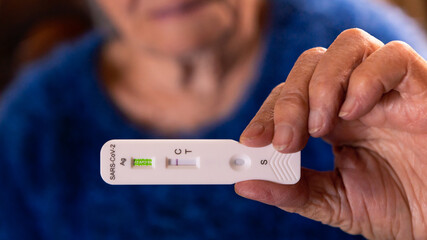 Obraz premium Grandma makes a rapid home test device for Covid19 virus with a negative result