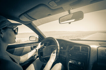 girl driving on the autobahn, moving towards the sun in a mountainous area, the problem of poor visibility of the road