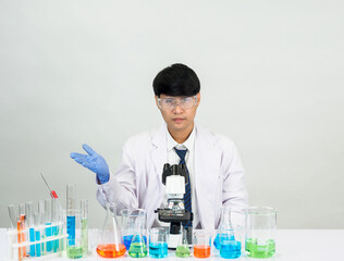 Asian male student scientist in reagent mixing laboratory In a science research laboratory with...