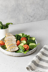 Grilled chicken breast, fillet and fresh vegetable salad of spinach, cucumber and tomato served for lunch. Healthy menu. Keto diet, detox food concept with text space
