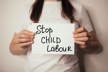 Stop child labour - woman hold card with lettering of social problem