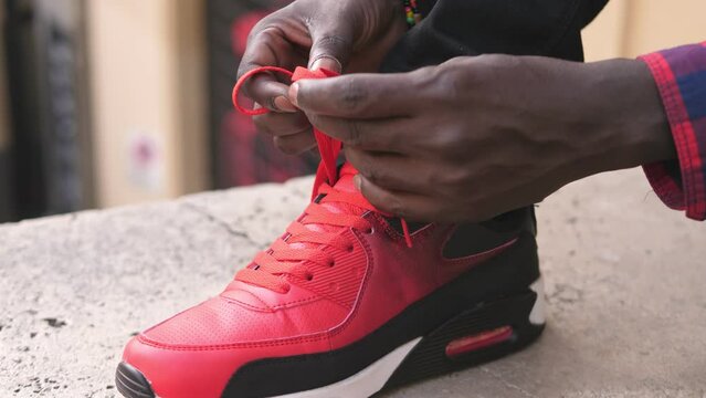 Close Up Of Black Man Tying Red Shoe Laces