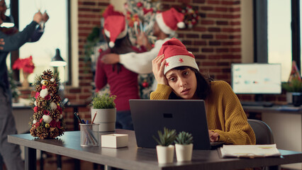 Festive people disturbing stressed woman during christmas time, feeling frustrated by noisy...