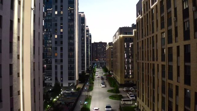 Top view of street with modern residential buildings. Stock footage. Beautiful street view of modern residential area of city. Glowing houses and streets of modern district