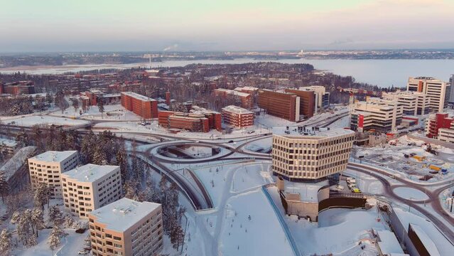 Espoo.Finland-February 3.2022: Aerial shot of Keilaranta in Espoo Finland during the cold nordic winter. Different buildings. Frozen sea. Snowy city. Drone slowly moving forward.
