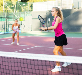 Sporty woman plays tennis. View through tennis net